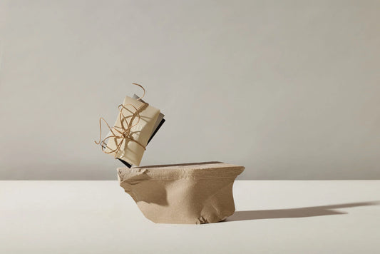 Ein Bündel mit kleinen Testverpackungen der Marke Estoras auf einem Stein balanciert