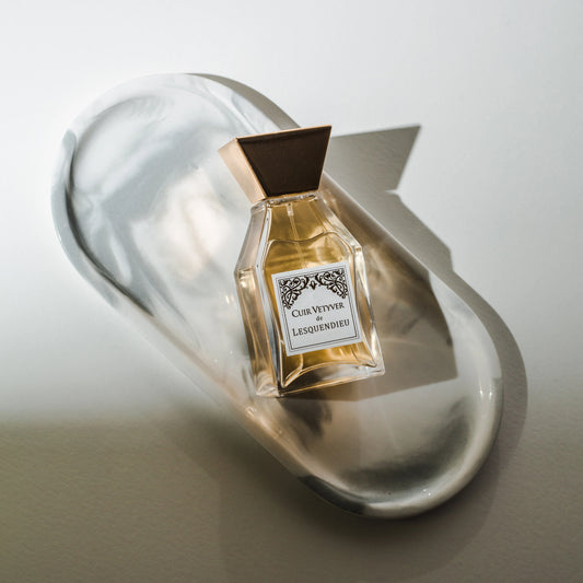 Das Flakon des exklusiven Nischenparfums Cuir Vetyver von der Marke Lesquendieu in einer weissen Marmorschale