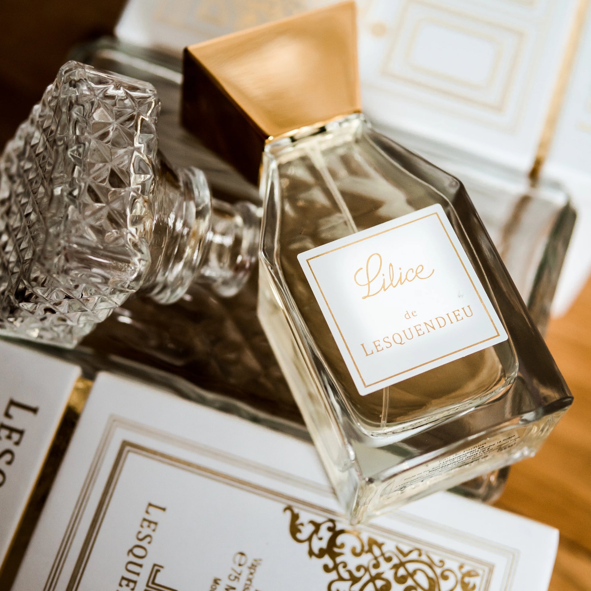 Das Flakon des exklusiven Nischenparfums Lilice von der Marke Lesquendieu auf Büchern mit einem Glasdeckel