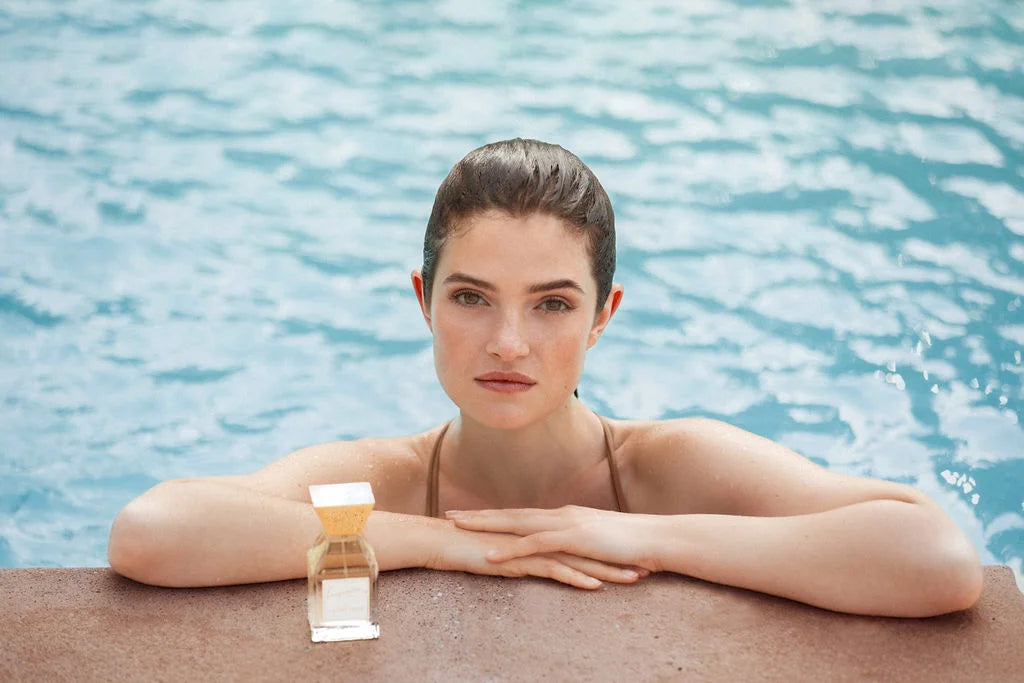 Frau im Wasser mit einem Nischenparfum von der Marke lesquendieu
