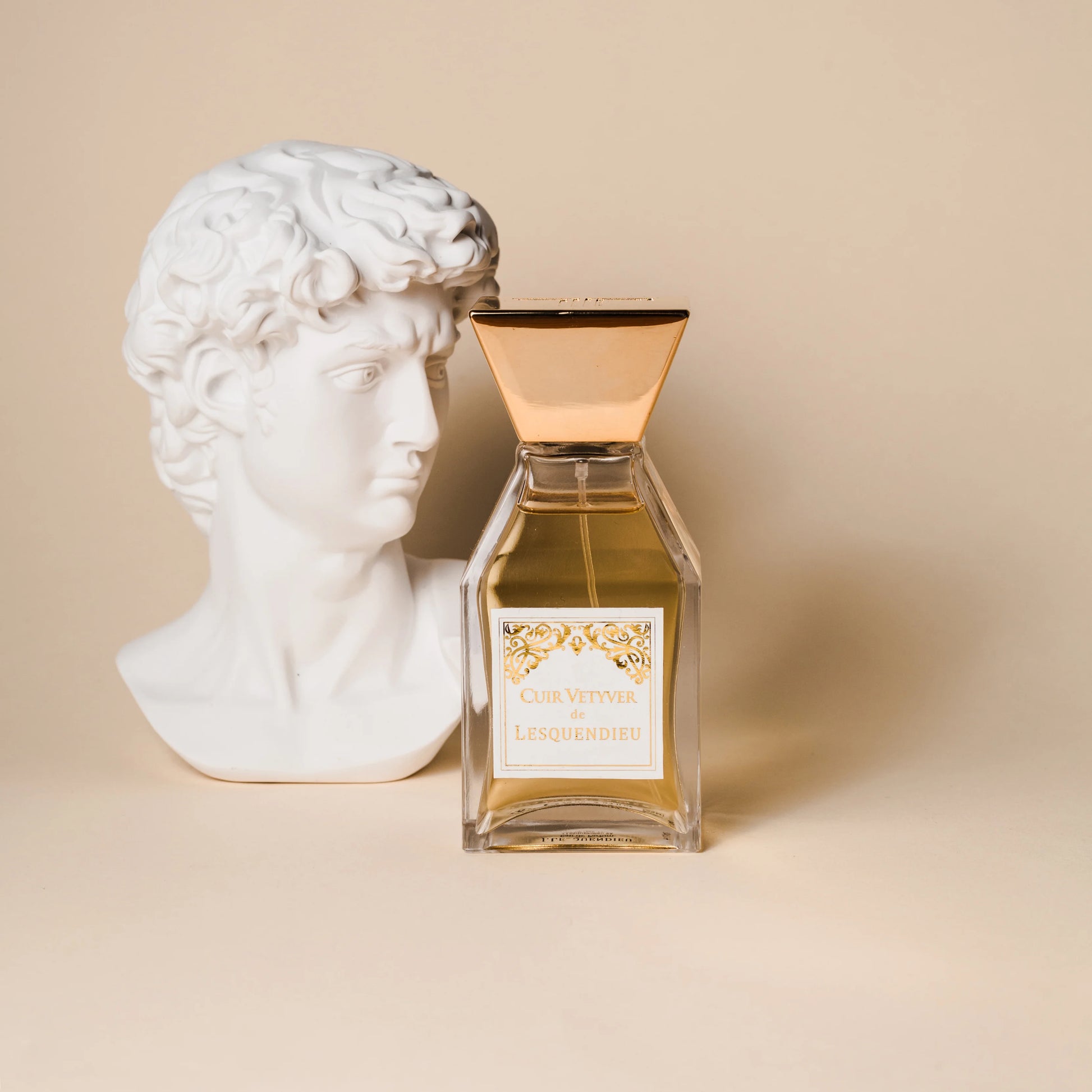 Das Flakon des exklusiven Nischenparfums Cuir Vetyver von der Marke Lesquendieu neben einer weissen Marmorbüste