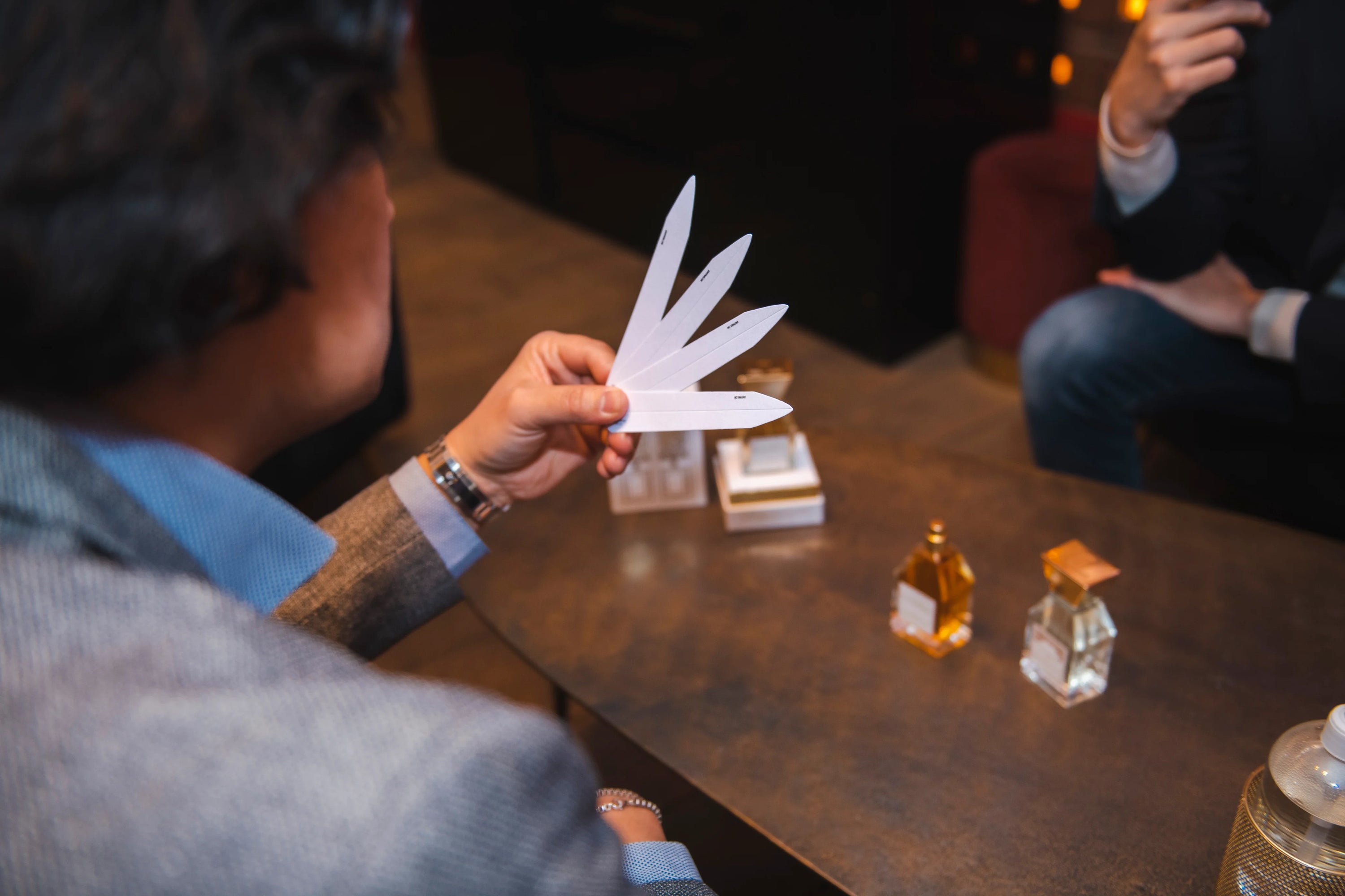 Der Parfümeur der Marke lesquendieu hält einige Textstreifen seiner Nischenparfums