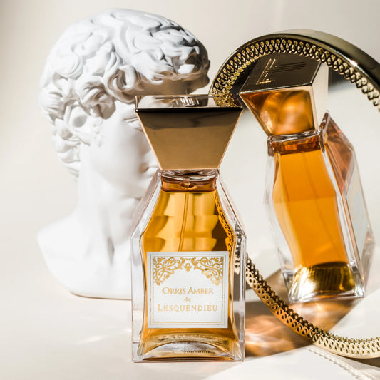 Das Flakon des exklusiven Nischenparfums Orris Amber von der Marke Lesquendieu vor einem Spiegel mit einer weissen Marmorbüste im Hintergrund 